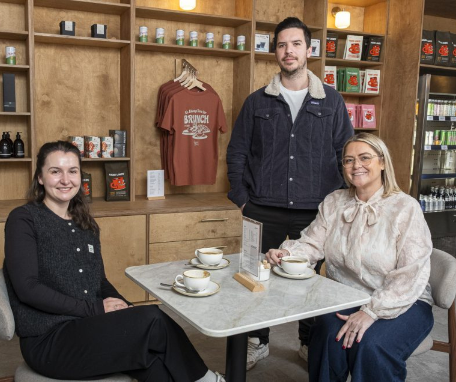 Ground owners Lois, Tom and UKSE representative, Michelle sit at table in Ground cafe in Whitchurch, Cardiff