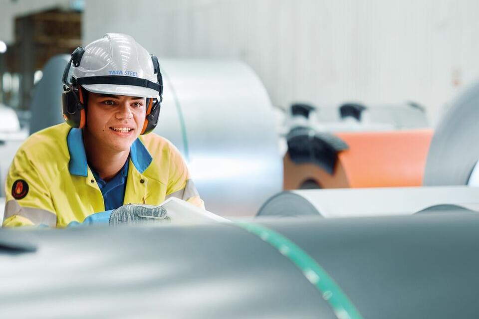Steel worker looking at coils