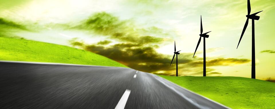 Futuristic picture depicting a road winding the countryside with wind turbines and a green sky Futuristic picture depicting a road winding the countryside with wind turbines and a green sky